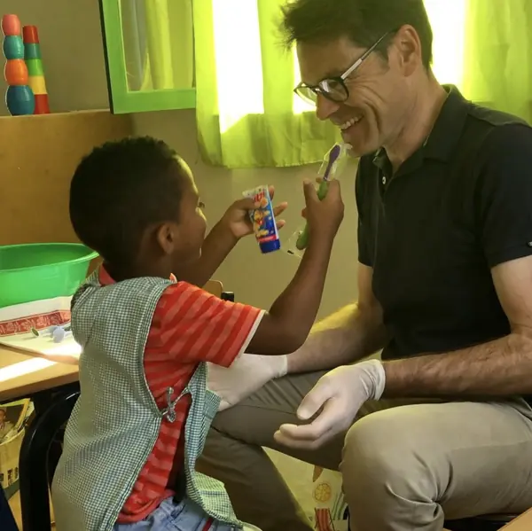Karsten Drewes übt mit einem Kind das Zähneputzen