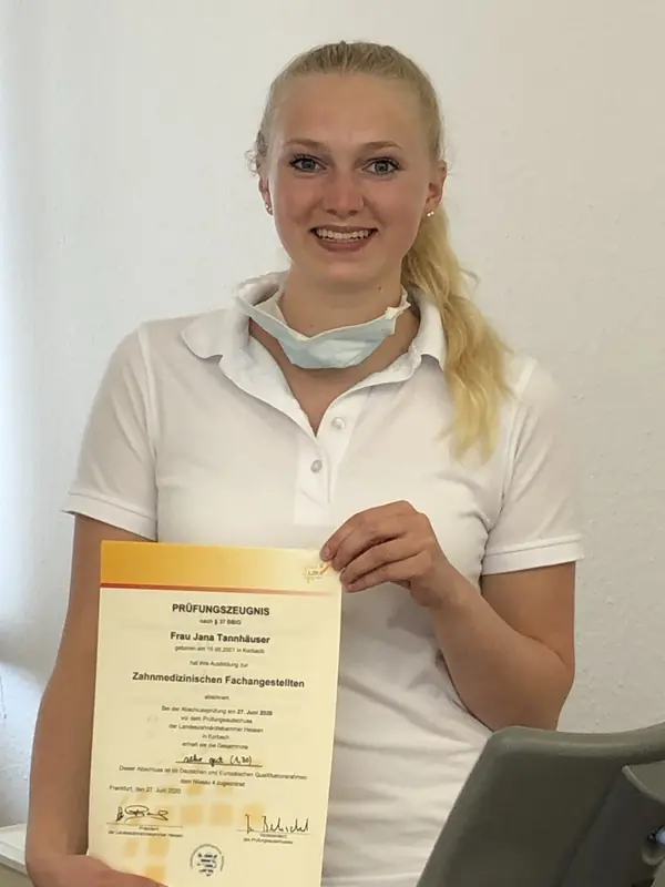 Mitarbeiterin mit ihrem Prüfungszeugnis